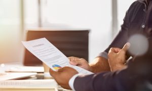 Two people looking over a proposal for increasing cybersecurity defenses