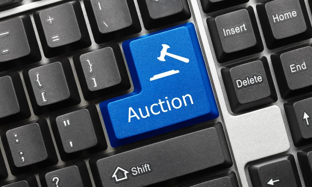 An auction button on a keyboard, part of the bidding process at Flippa.