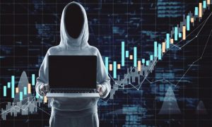 A hacker wearing a hoodie, holding a laptop, and considering the rising cost of cyber attacks